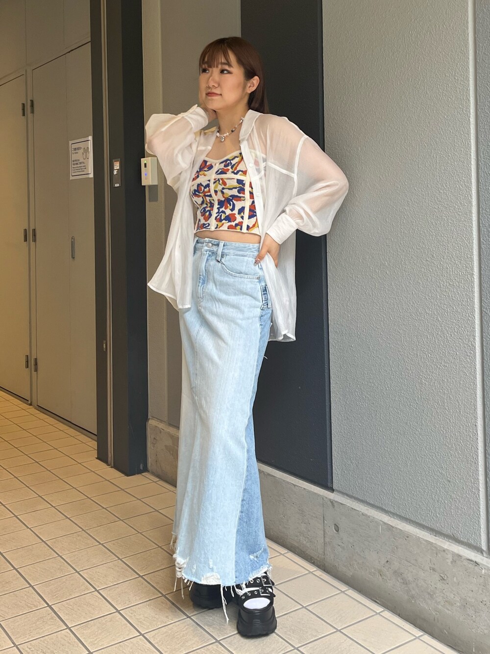 ホワイト系のシャツ/ブラウス、ブラック系のサンダル、ブルー系のデニムスカートを着用したレディースの春コーディネートの2枚目の写真