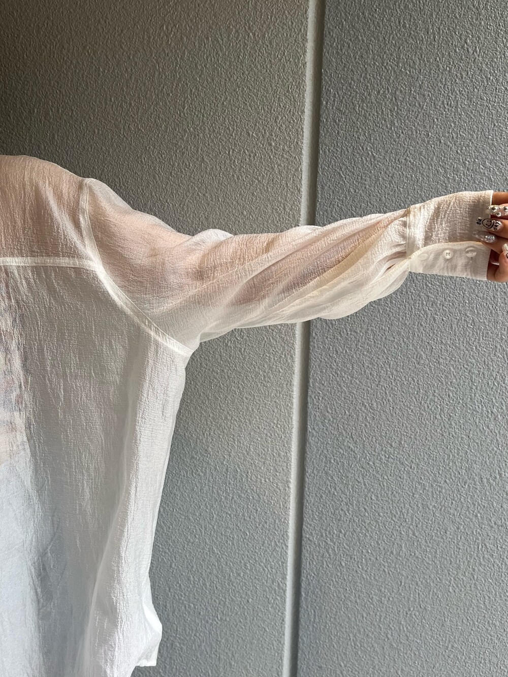 ホワイト系のシャツ/ブラウス、ブラック系のサンダル、ブルー系のデニムスカートを着用したレディースの春コーディネートの6枚目の写真