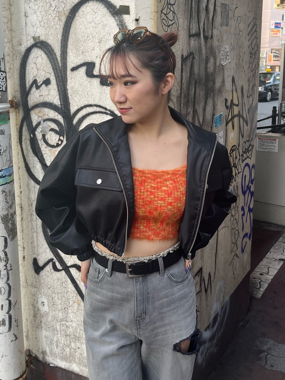 ブラック系のデニムパンツ、ブラック系のブーツ、オレンジ系のニット/セーターを着用したレディースの冬コーディネートの3枚目の写真