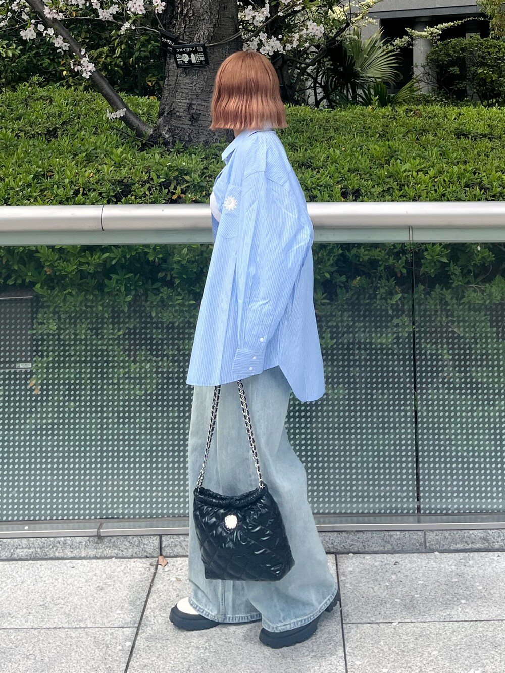 ブラック系のショルダーバッグ、ブルー系のシャツ/ブラウス、ブルー系のデニムパンツを着用したレディースの春コーディネートの3枚目の写真