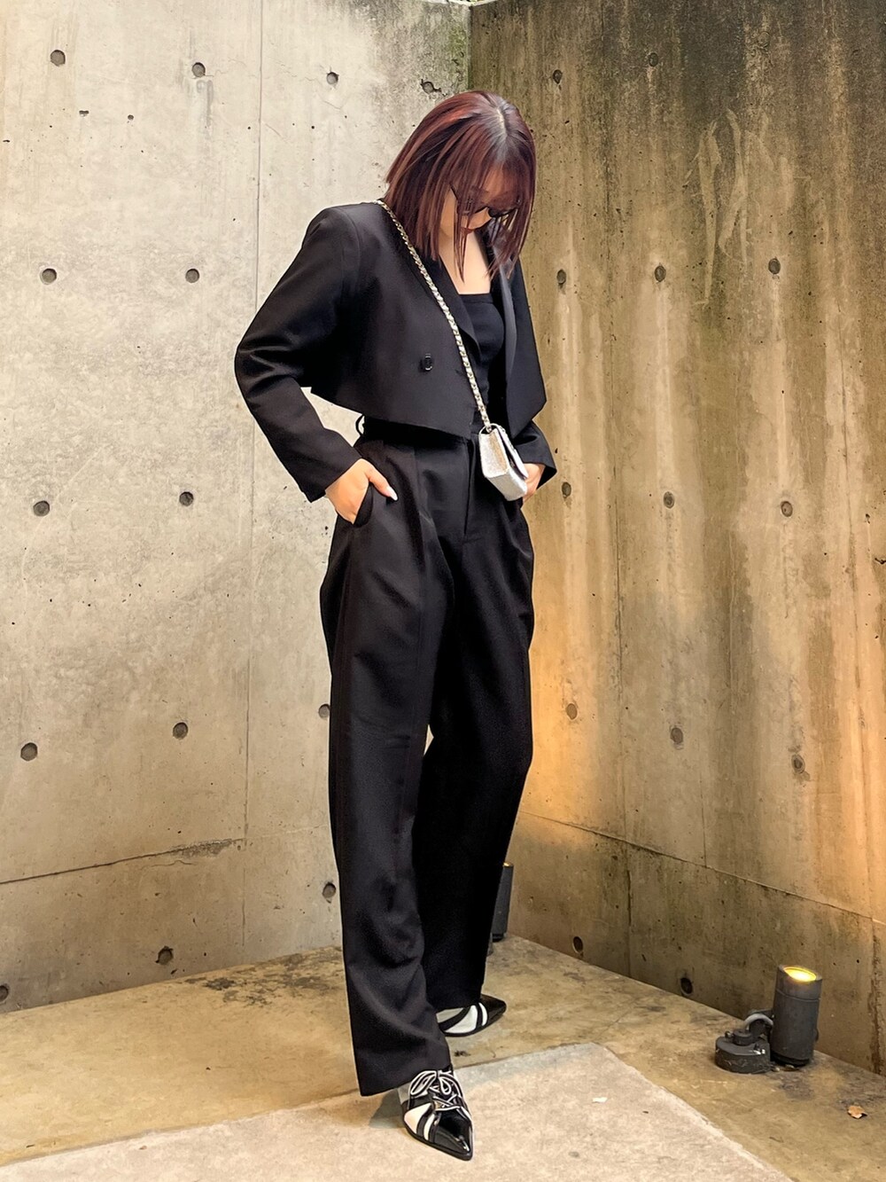 ブラック系のキャミソール、ブラック系のその他パンツ、ブラック系のテーラードジャケットを着用したレディースの春コーディネートの2枚目の写真