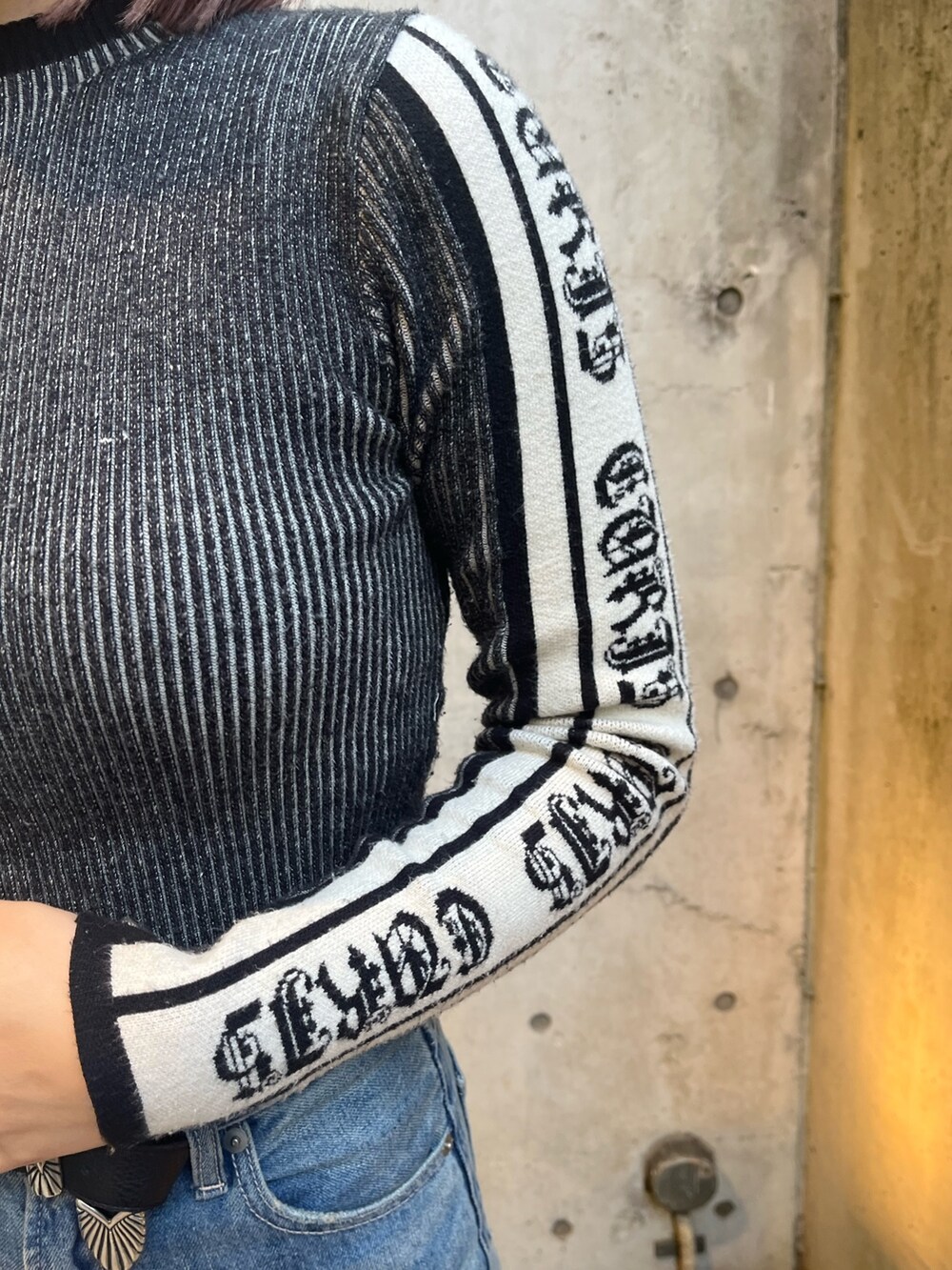 ブラック系のニット/セーター、ブルー系のデニムパンツ、レッド系のショルダーバッグを着用したレディースの冬コーディネートの5枚目の写真