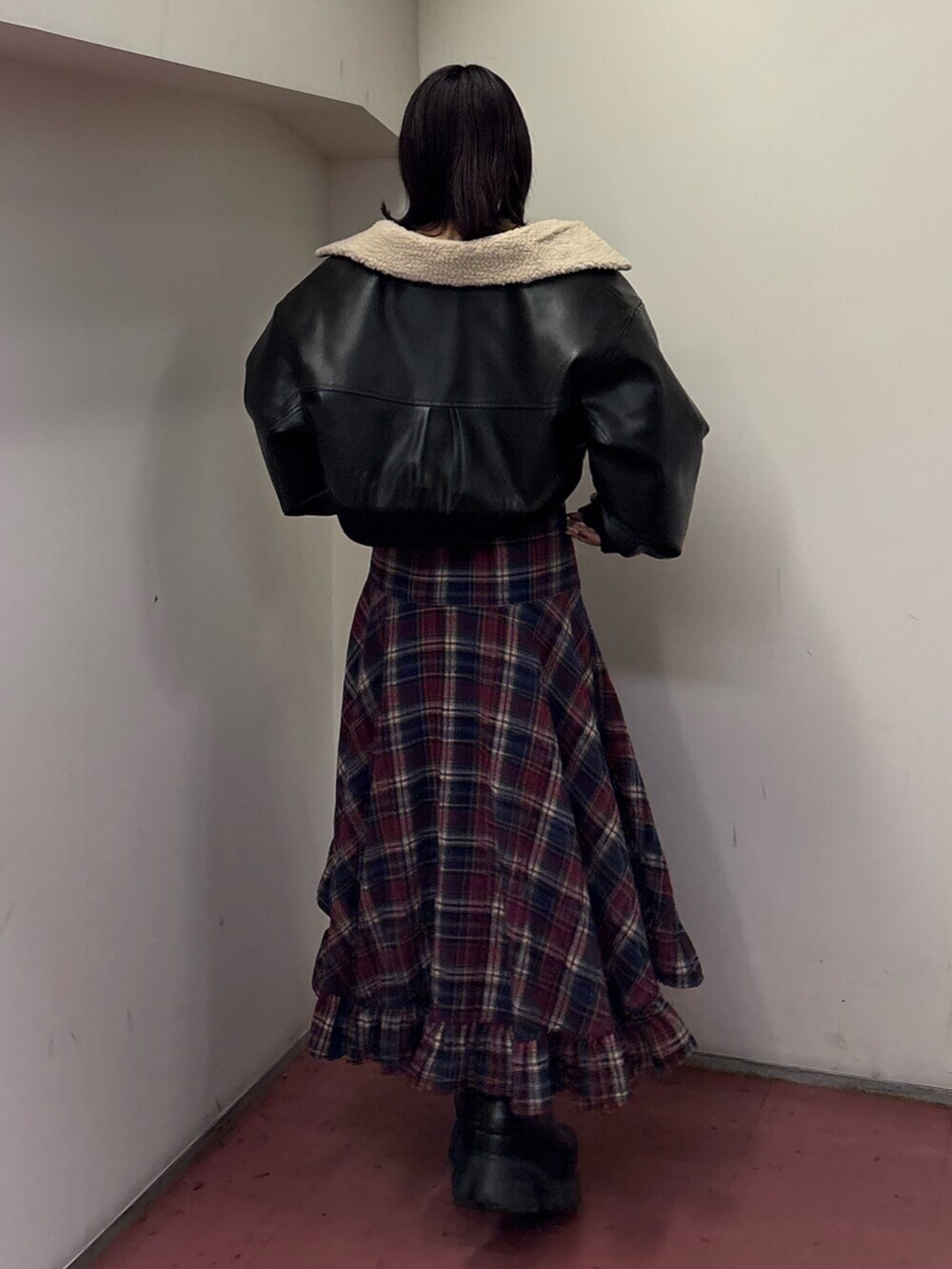 ブラック系のブーツ、ブルー系のスカート、ブラック系のブルゾンを着用したレディースの冬コーディネートの2枚目の写真