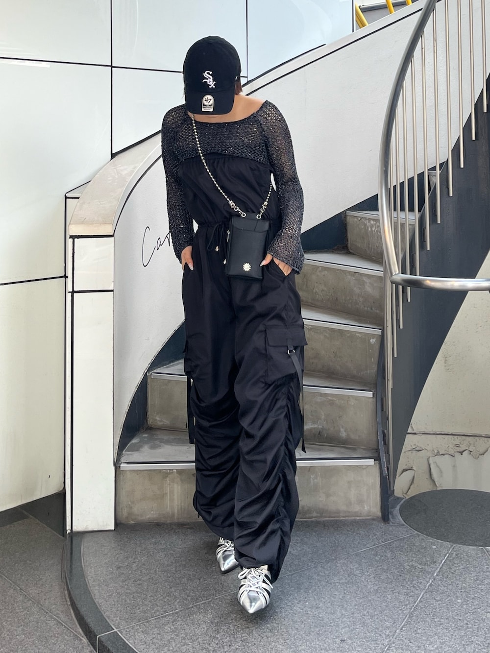 ブラック系のつなぎ/オールインワン、シルバー系のサンダル、ブラック系のショルダーバッグを着用したレディースの春コーディネートの2枚目の写真