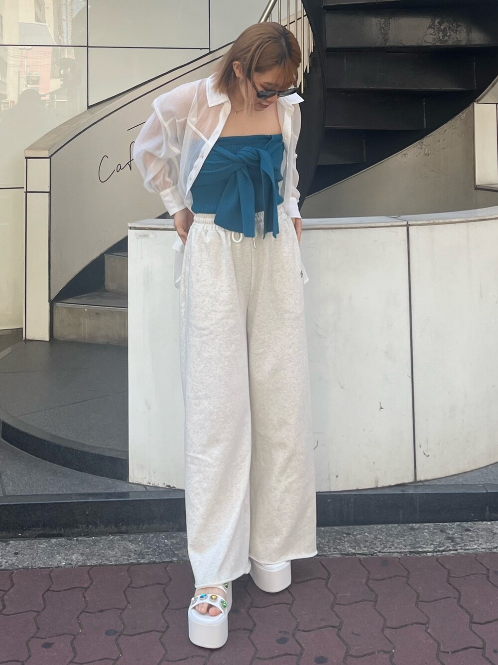 ホワイト系のスウェットパンツ、ホワイト系のサンダル、ブルー系のキャミソールを着用したレディースの春コーディネートの2枚目の写真