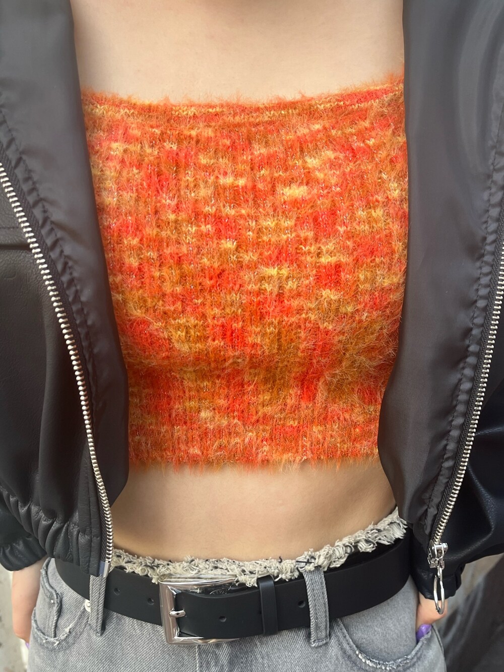 ブラック系のデニムパンツ、ブラック系のブーツ、オレンジ系のニット/セーターを着用したレディースの冬コーディネートの4枚目の写真