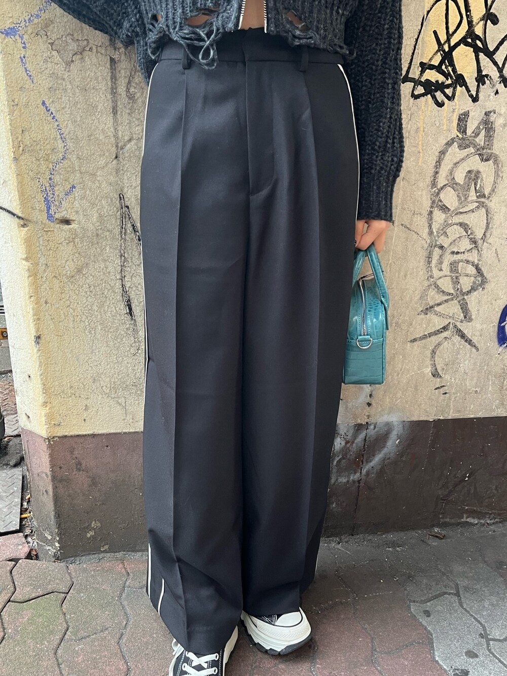 ブラック系のその他パンツ、ブルー系のショルダーバッグ、ブラック系のニット/セーターを着用したレディースの冬コーディネートの5枚目の写真