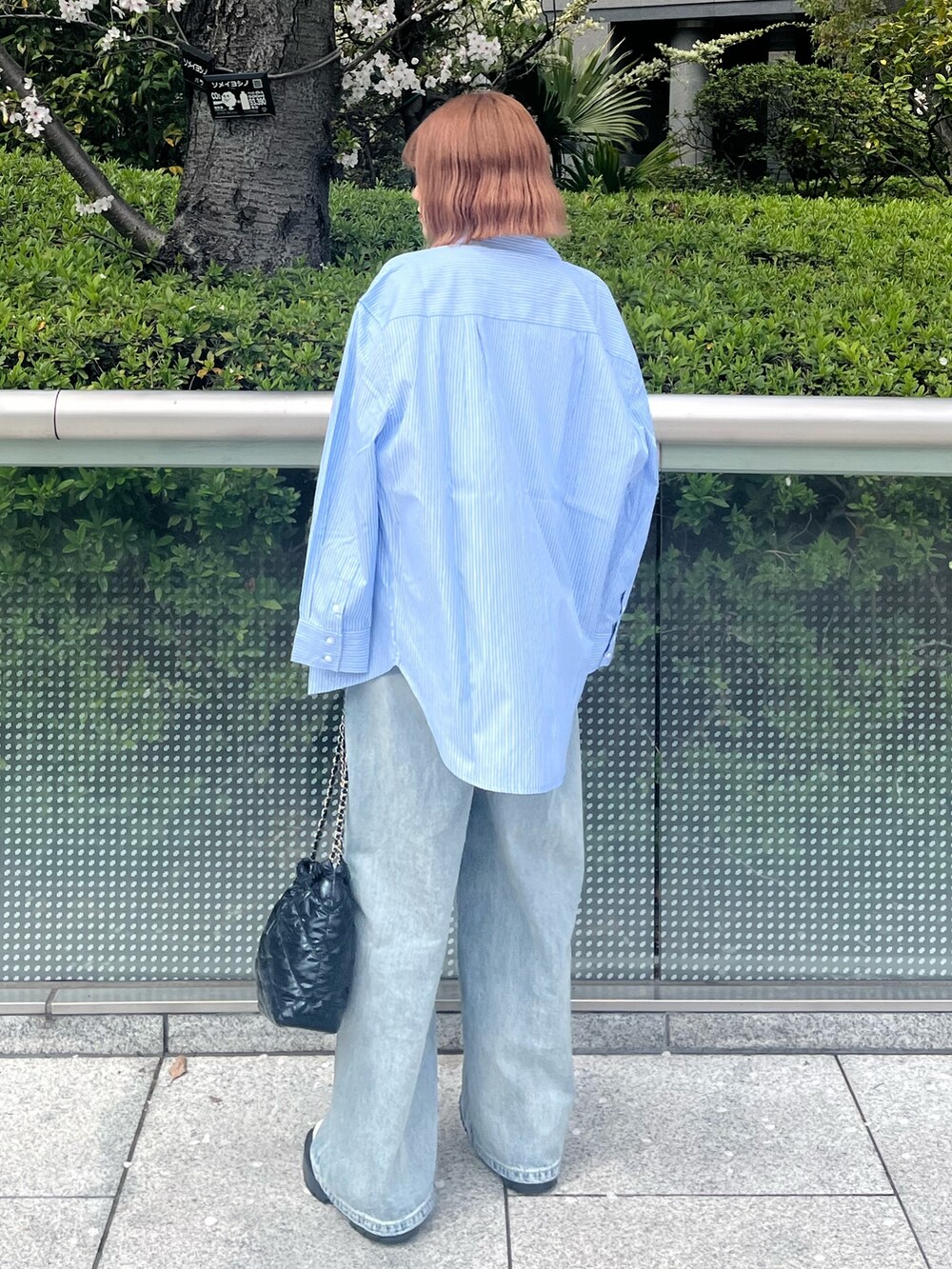 ブラック系のショルダーバッグ、ブルー系のシャツ/ブラウス、ブルー系のデニムパンツを着用したレディースの春コーディネートの4枚目の写真