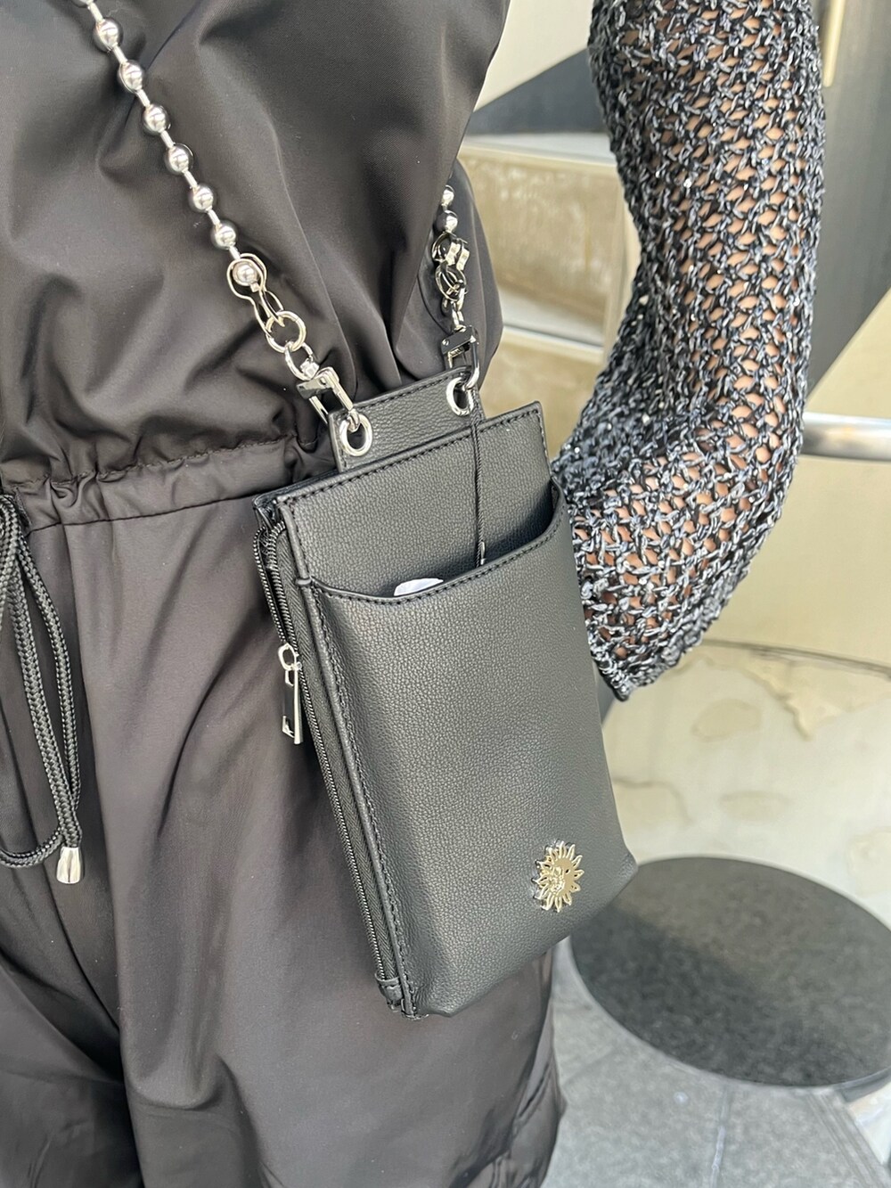 ブラック系のつなぎ/オールインワン、シルバー系のサンダル、ブラック系のショルダーバッグを着用したレディースの春コーディネートの5枚目の写真