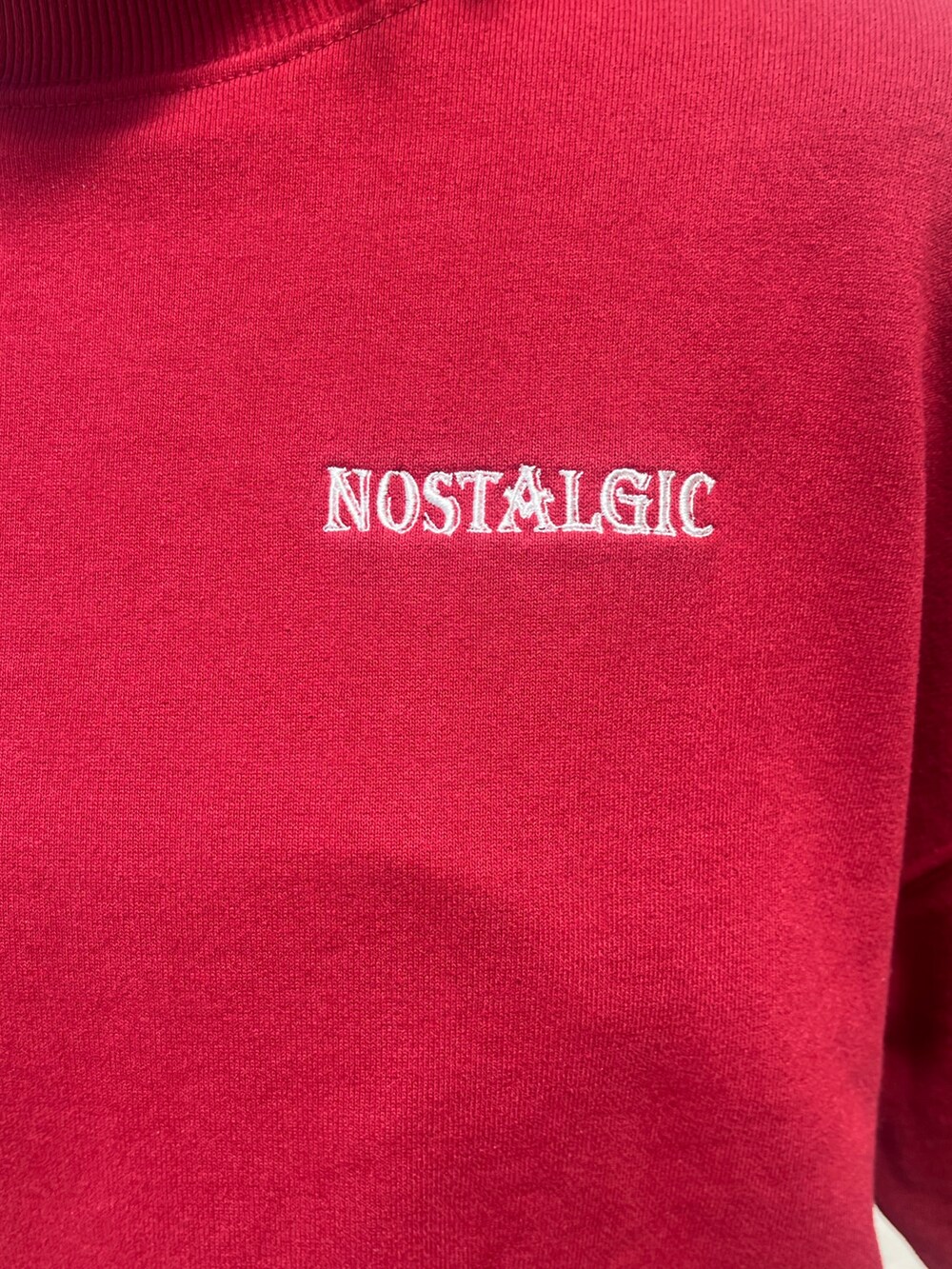 ブラック系のデニムスカート、レッド系のスウェット、ブラック系のブーツを着用したレディースの秋コーディネートの6枚目の写真