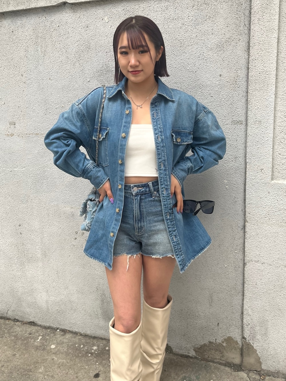 ブルー系のデニムパンツ、ホワイト系のキャミソール、ブルー系のシャツ/ブラウスを着用したレディースの春コーディネートの5枚目の写真