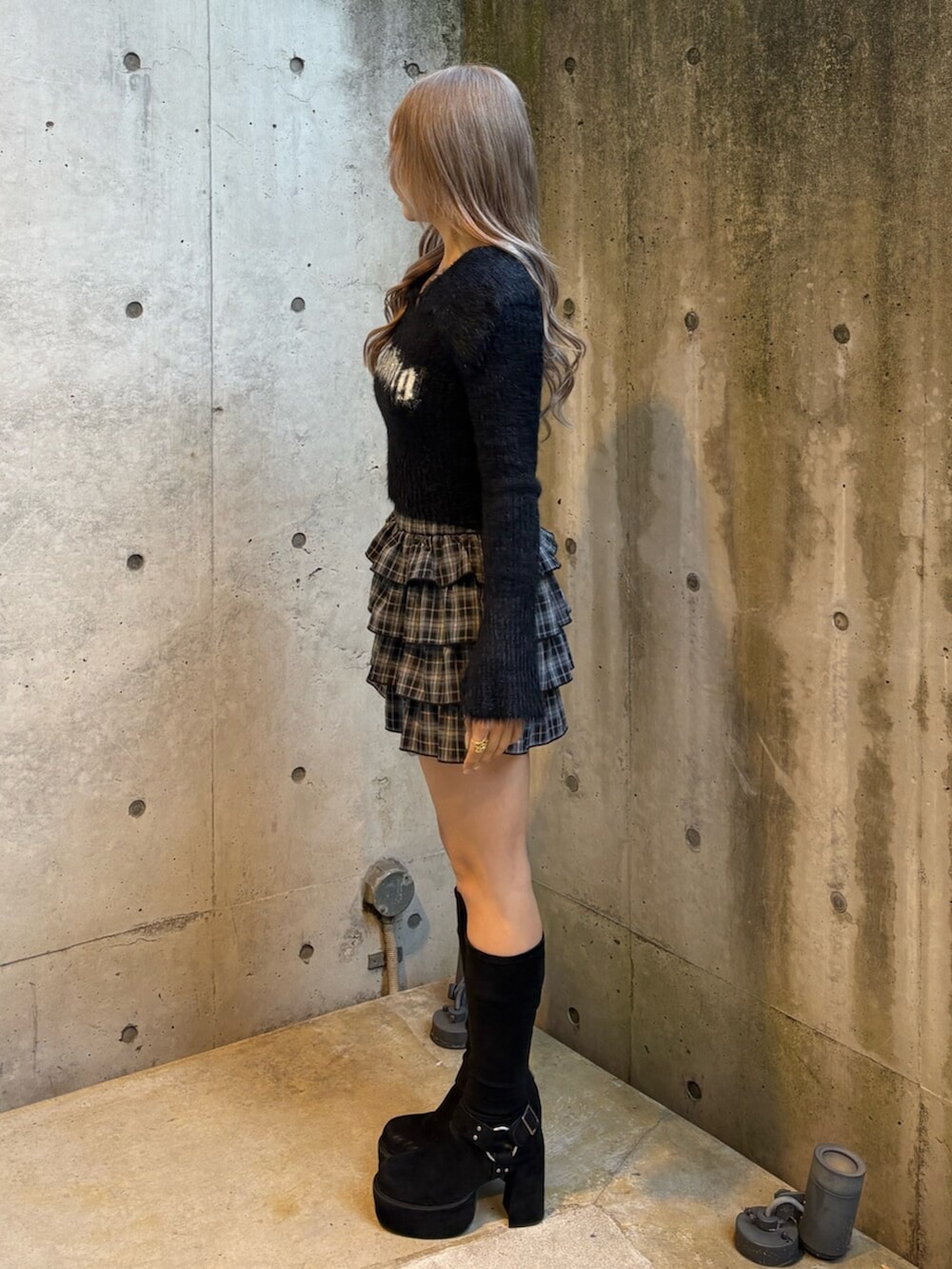 ブラック系のブーツ、ブラック系のスカート、ブラック系のニット/セーターを着用したレディースの冬コーディネートの2枚目の写真