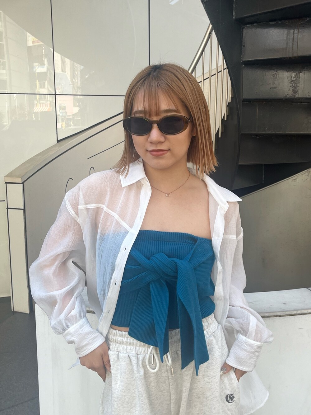 ホワイト系のスウェットパンツ、ホワイト系のサンダル、ブルー系のキャミソールを着用したレディースの春コーディネートの5枚目の写真