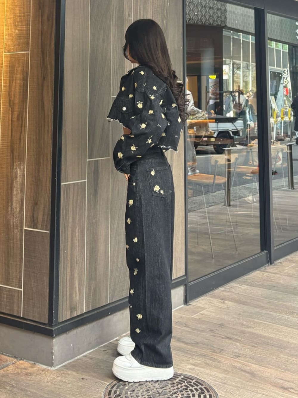 ブラック系のデニムパンツ、ブラック系のデニムジャケット、グレー系のニット/セーターを着用したレディースの冬コーディネートの2枚目の写真