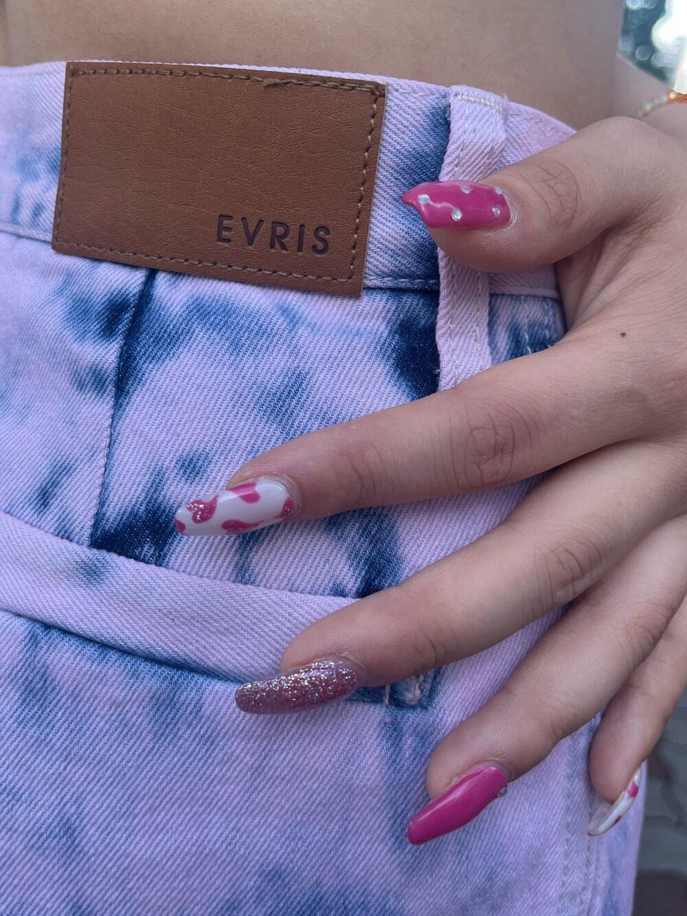 ピンク系のデニムパンツ、ブラック系のサンダル、ブラック系のTシャツ/カットソーを着用したレディースの夏コーディネートの7枚目の写真