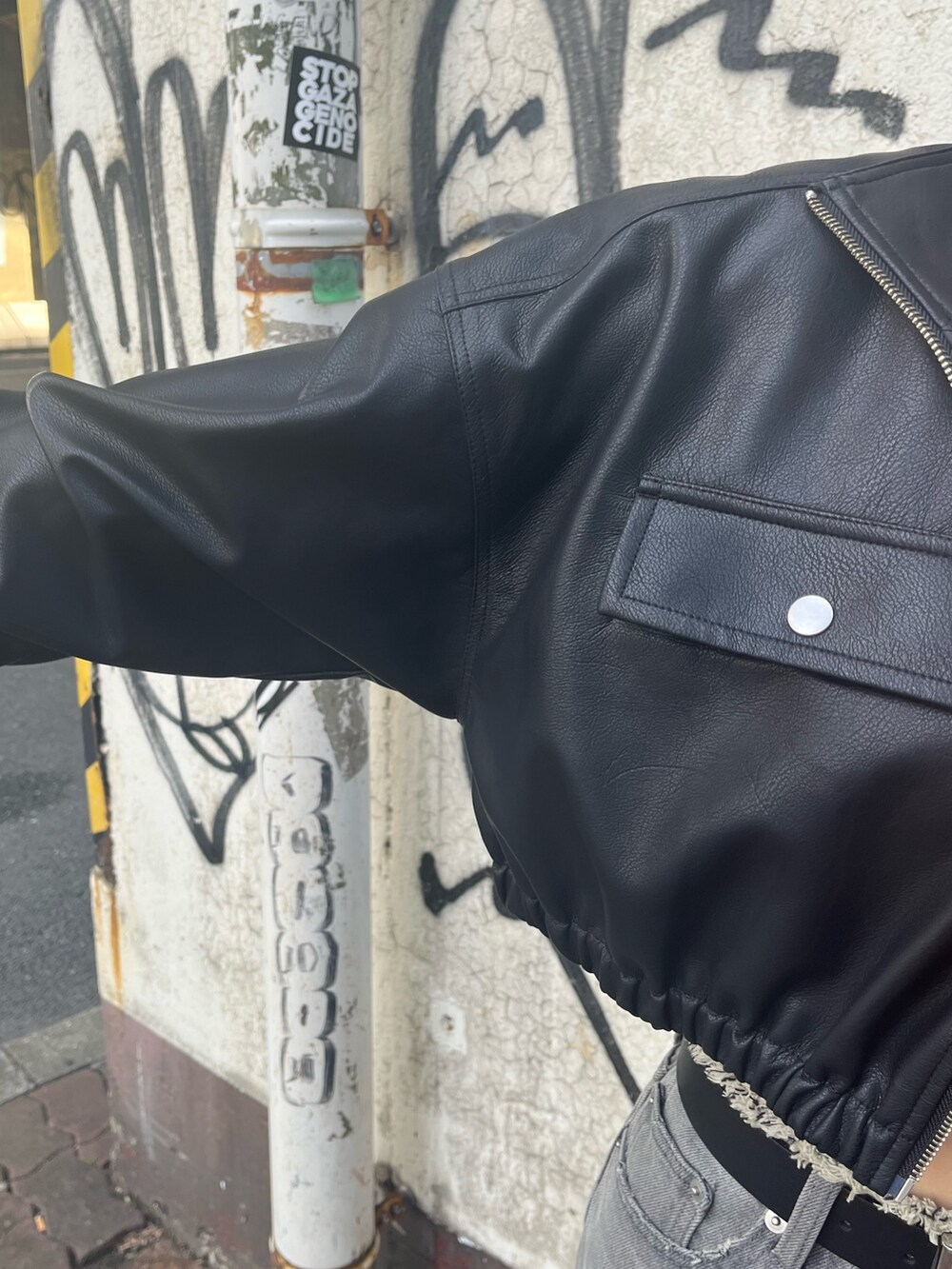 ブラック系のデニムパンツ、ブラック系のブーツ、オレンジ系のニット/セーターを着用したレディースの冬コーディネートの5枚目の写真