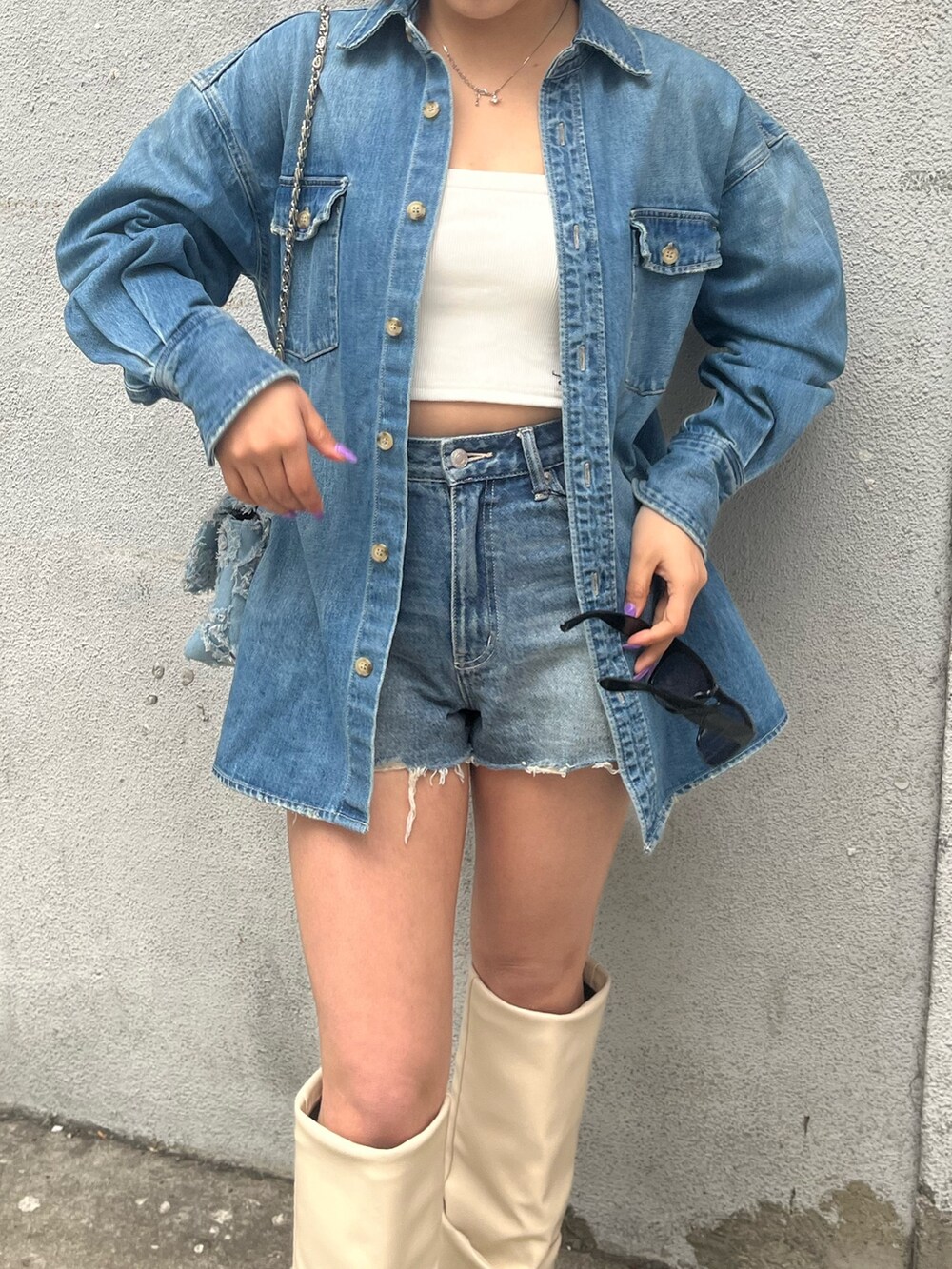 ブルー系のデニムパンツ、ホワイト系のキャミソール、ブルー系のシャツ/ブラウスを着用したレディースの春コーディネートの4枚目の写真