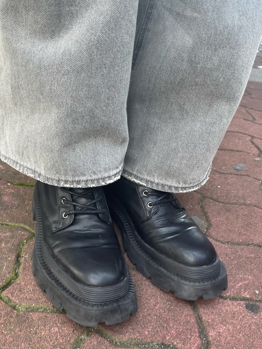 ブラック系のデニムパンツ、ブラック系のブーツ、オレンジ系のニット/セーターを着用したレディースの冬コーディネートの7枚目の写真