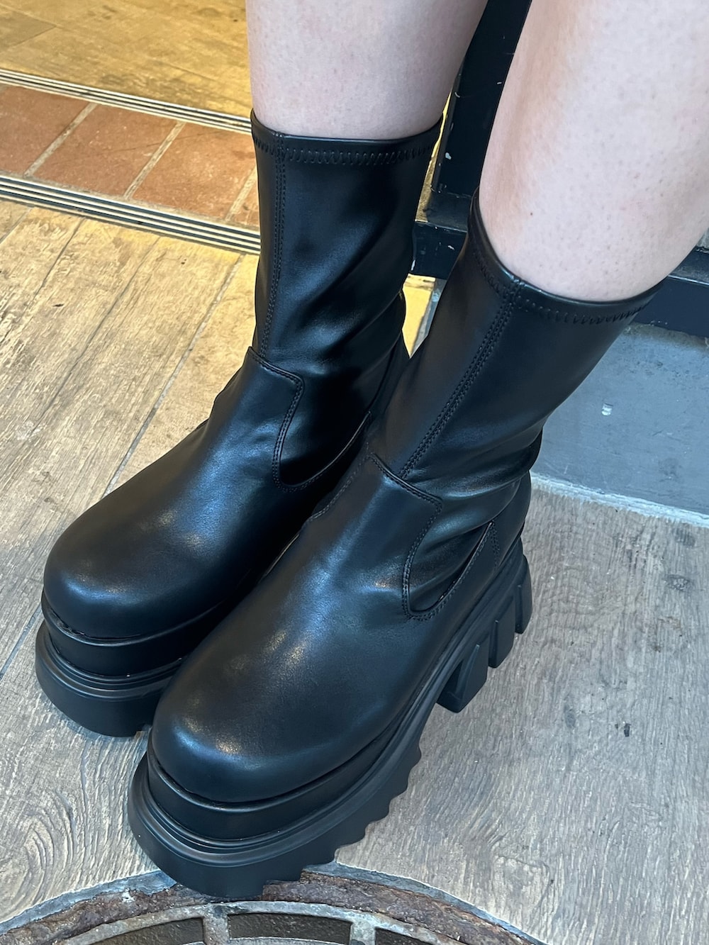 グレー系のニット/セーター、ブラック系のショルダーバッグ、ブラック系のブーツを着用したレディースの秋コーディネートの9枚目の写真