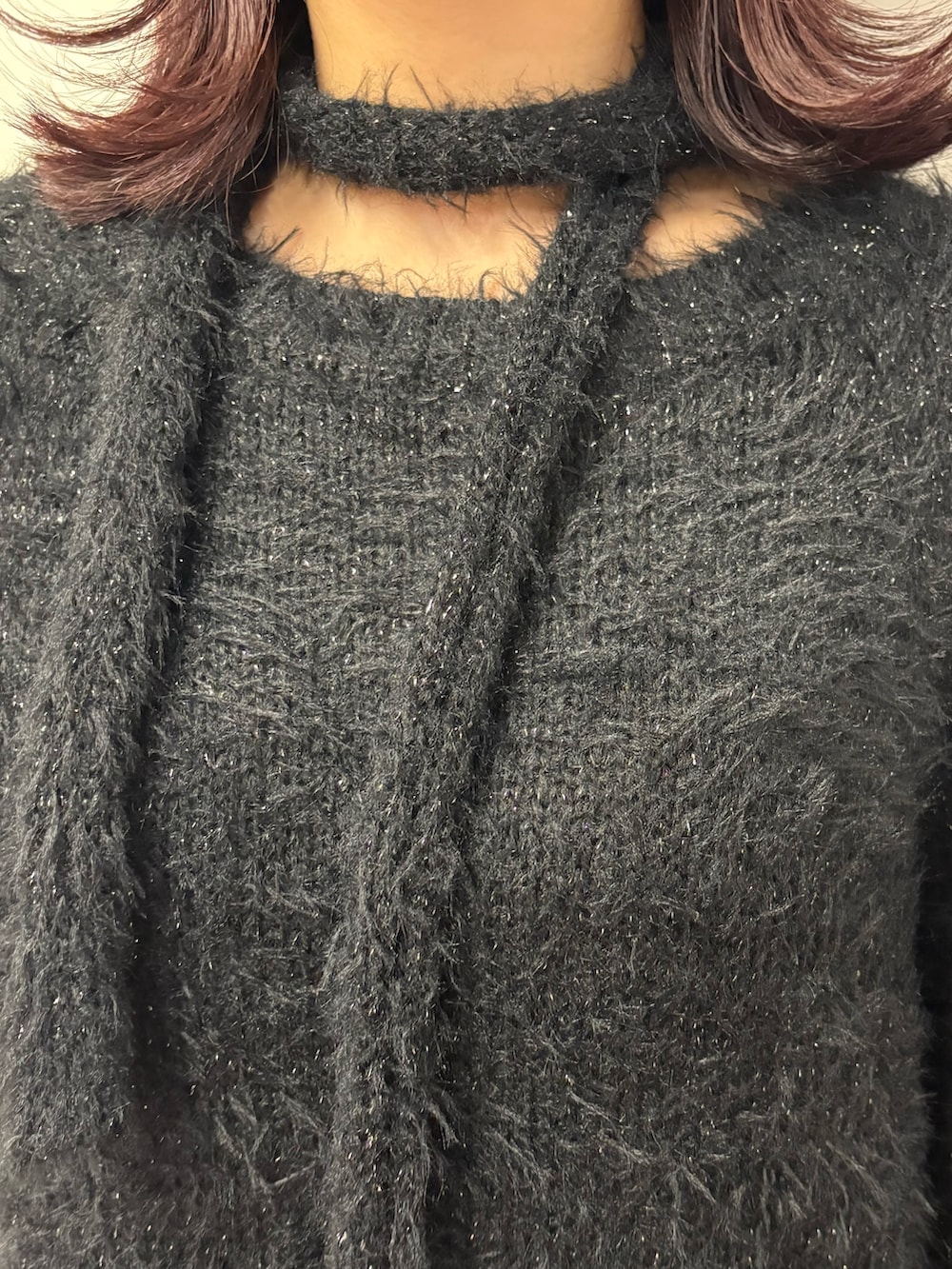 ブラック系のワンピース、ブラック系のショルダーバッグ、グリーン系のブーツを着用したレディースの冬コーディネートの7枚目の写真