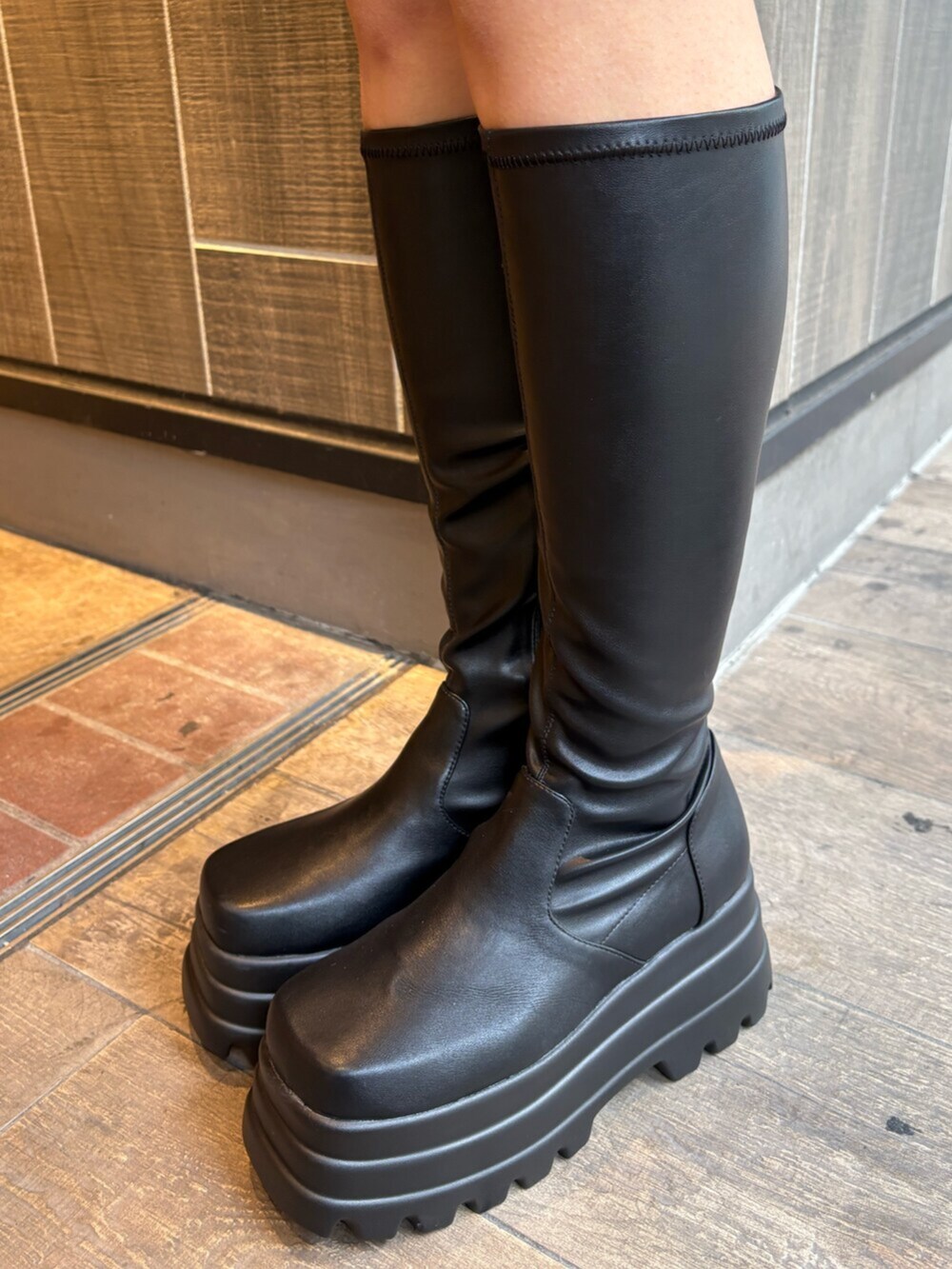 グレー系のブルゾン、ブラック系のつなぎ/オールインワン、ブラック系のブーツを着用したレディースの冬コーディネートの9枚目の写真