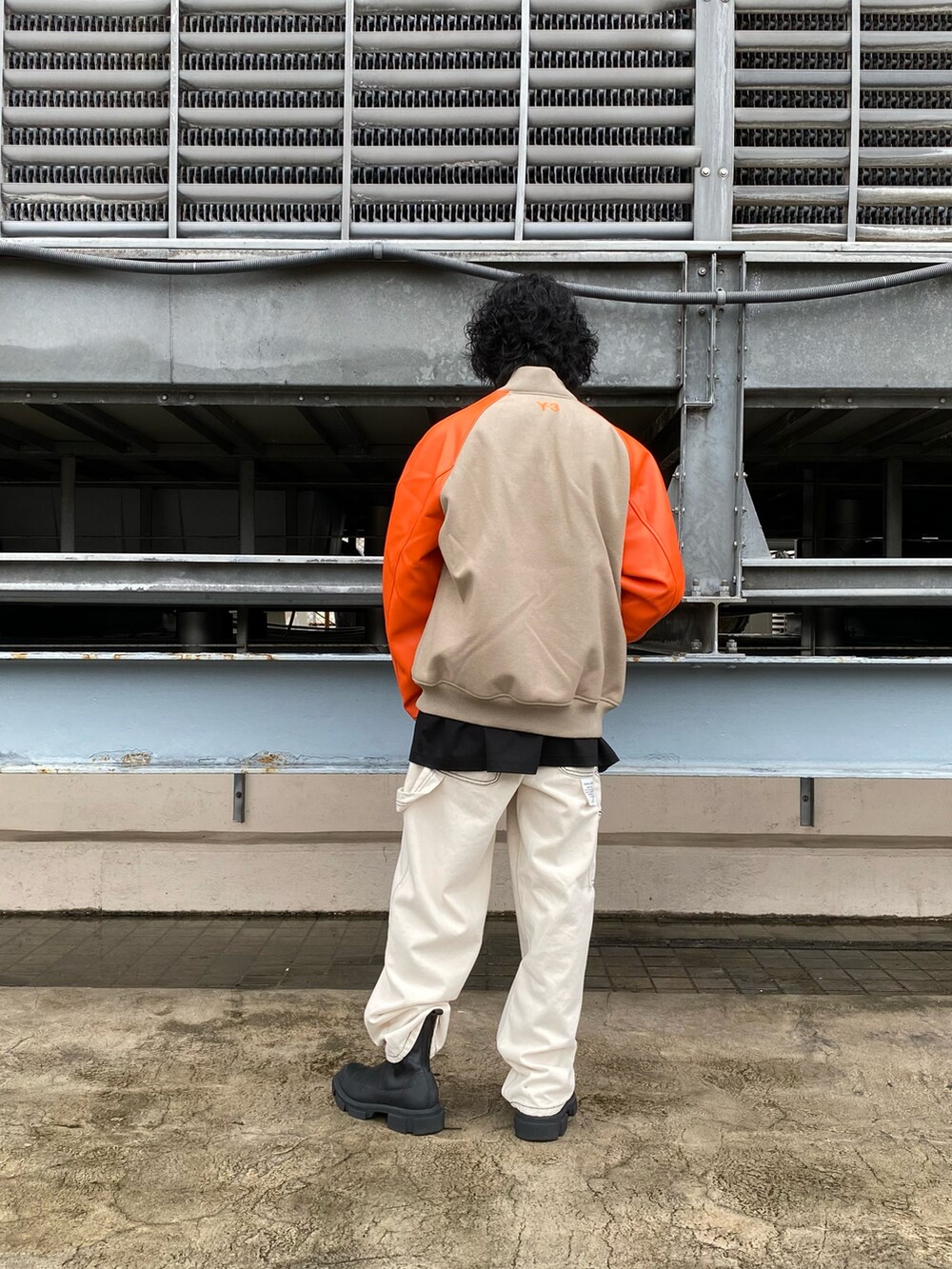 オレンジ系のブルゾン、ブラック系のTシャツ/カットソー、ブラック系のTシャツ/カットソーを着用したメンズの秋コーディネートの2枚目の写真