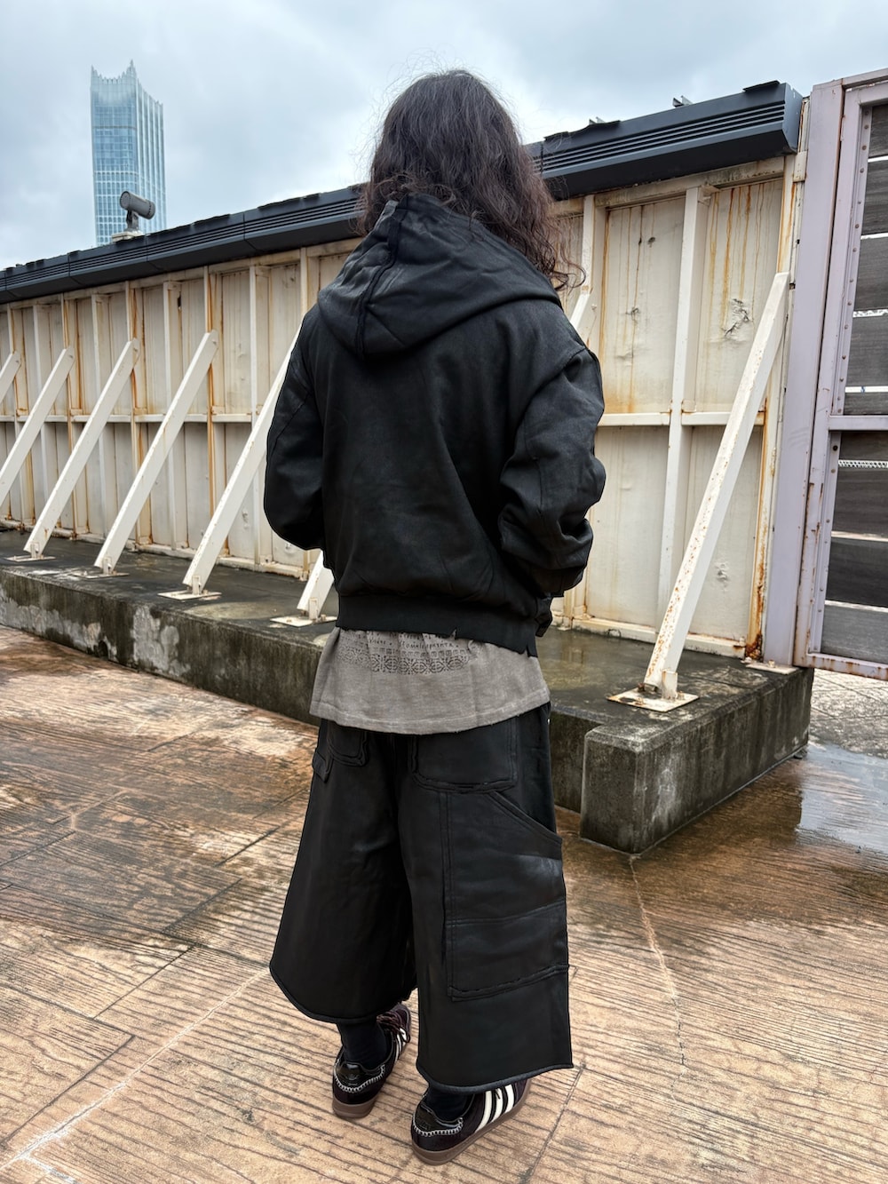 ブラック系のパーカー、ベージュ系のTシャツ/カットソー、ブラック系のスウェットパンツを着用したメンズの秋コーディネートの2枚目の写真
