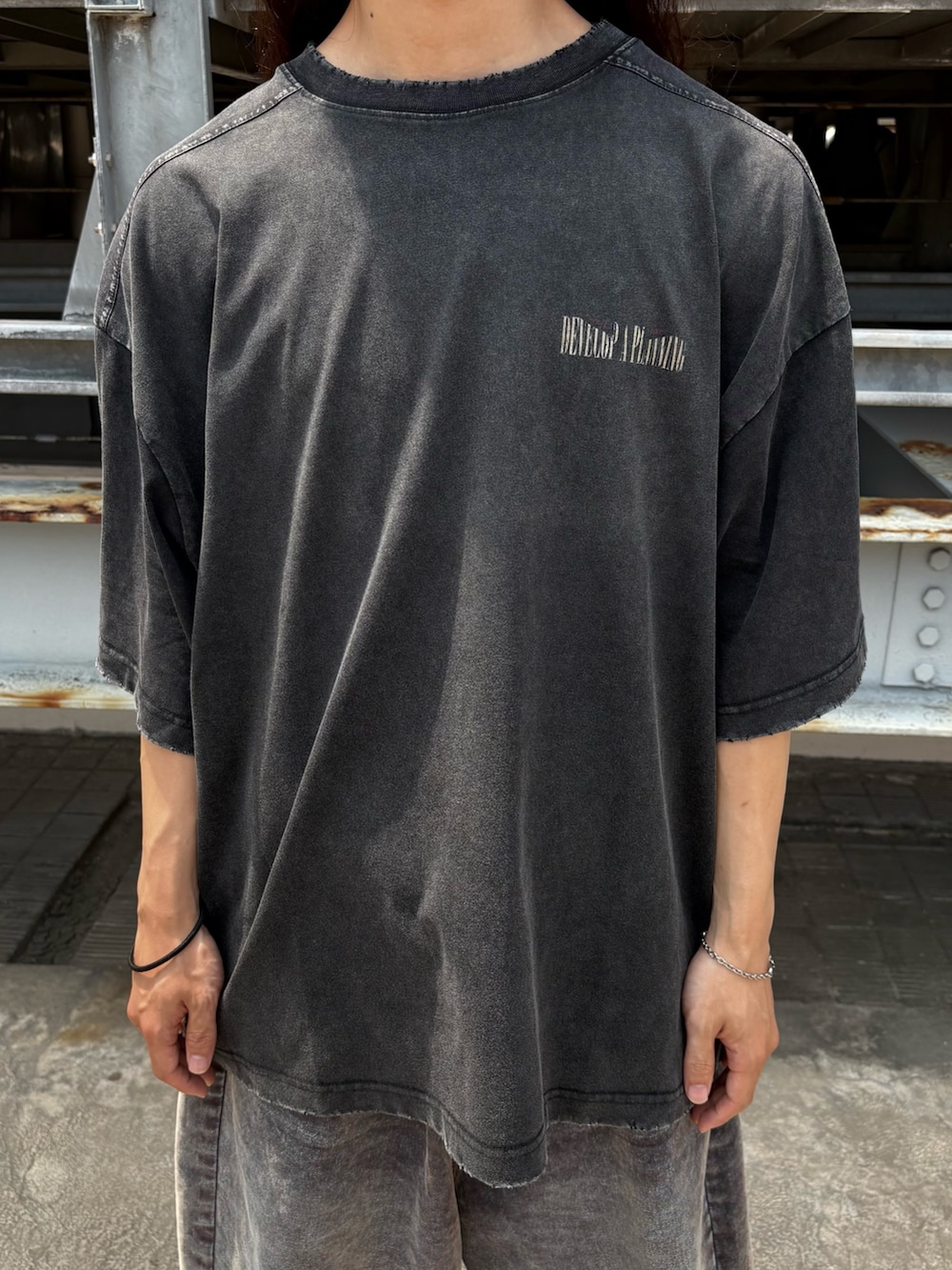 ブラック系のTシャツ/カットソー、ブルー系のデニムパンツを着用したメンズの夏コーディネートの3枚目の写真