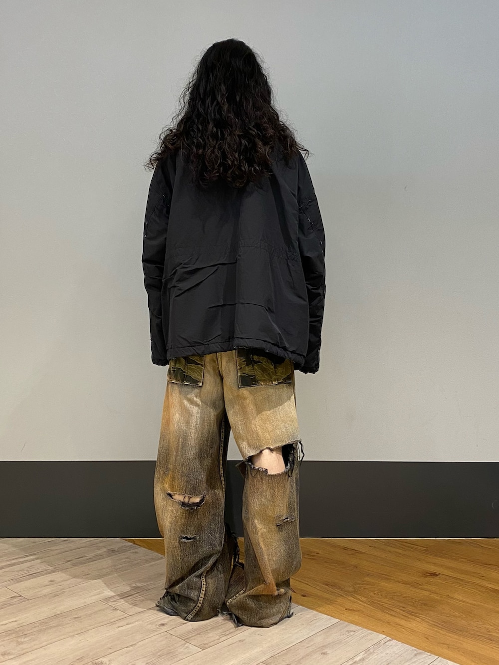 ブラック系のミリタリージャケットを着用したメンズの秋コーディネートの2枚目の写真