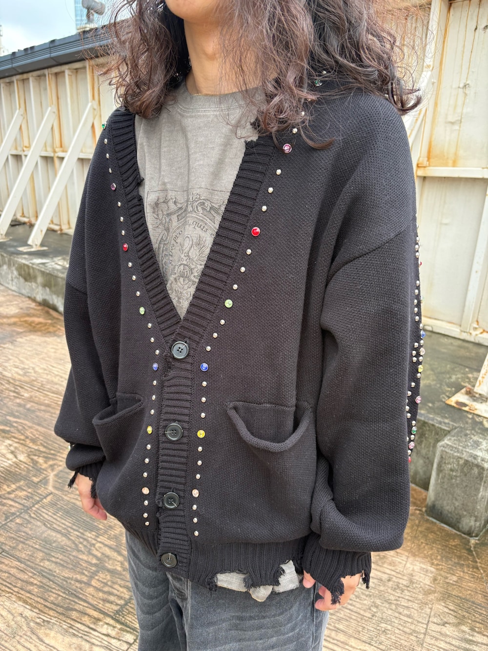 ブラック系のカーディガン/ボレロ、ベージュ系のTシャツ/カットソー、ブラック系のデニムパンツを着用したメンズの秋コーディネートの3枚目の写真