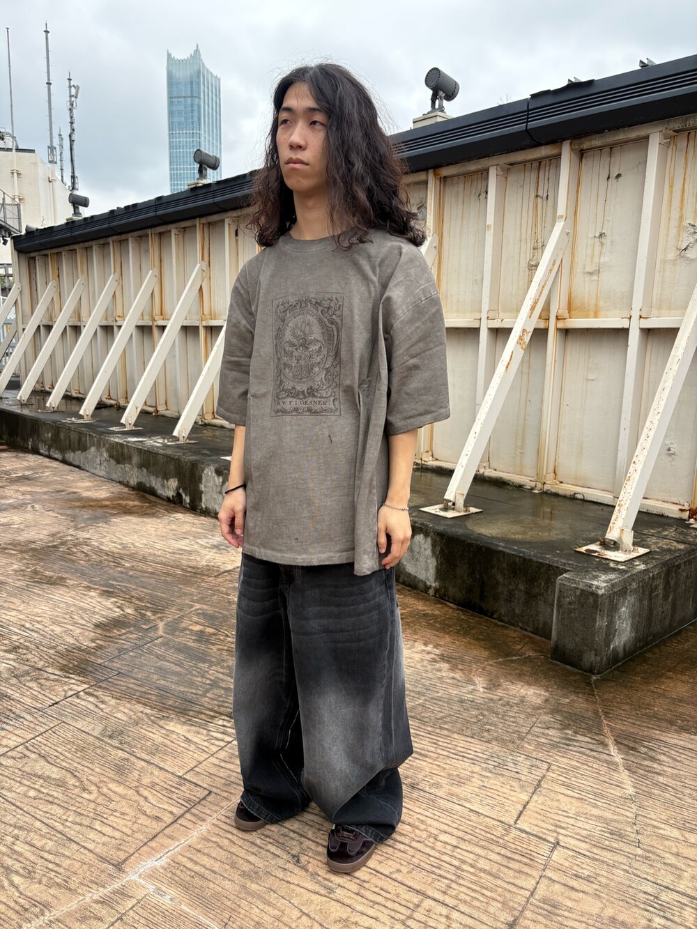 ブラック系のカーディガン/ボレロ、ベージュ系のTシャツ/カットソー、ブラック系のデニムパンツを着用したメンズの秋コーディネートの5枚目の写真