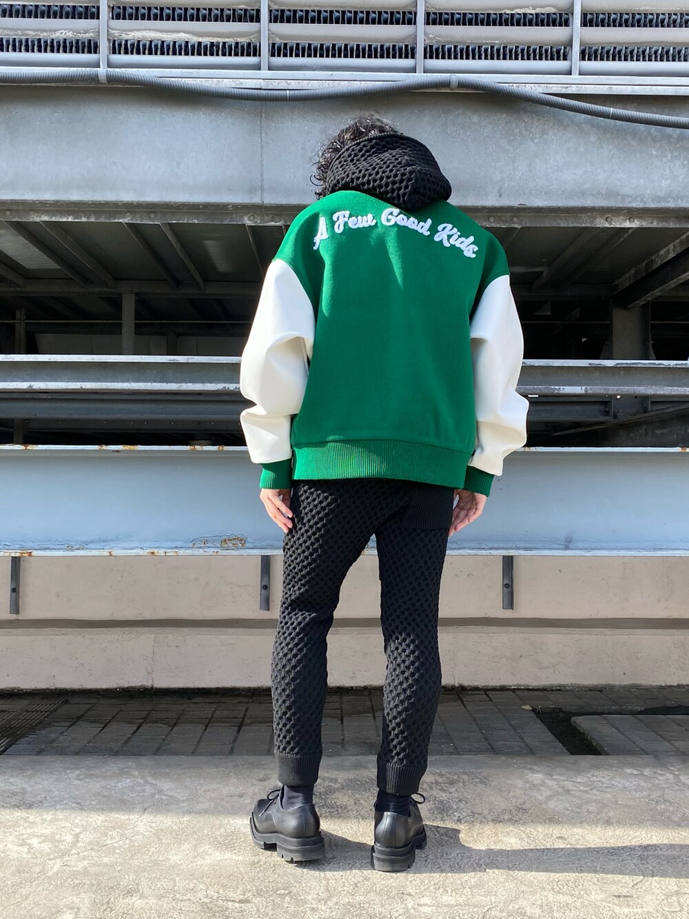 グリーン系のスタジャン、ブラック系のパーカー、ブラック系のパーカーを着用したメンズの冬コーディネートの2枚目の写真