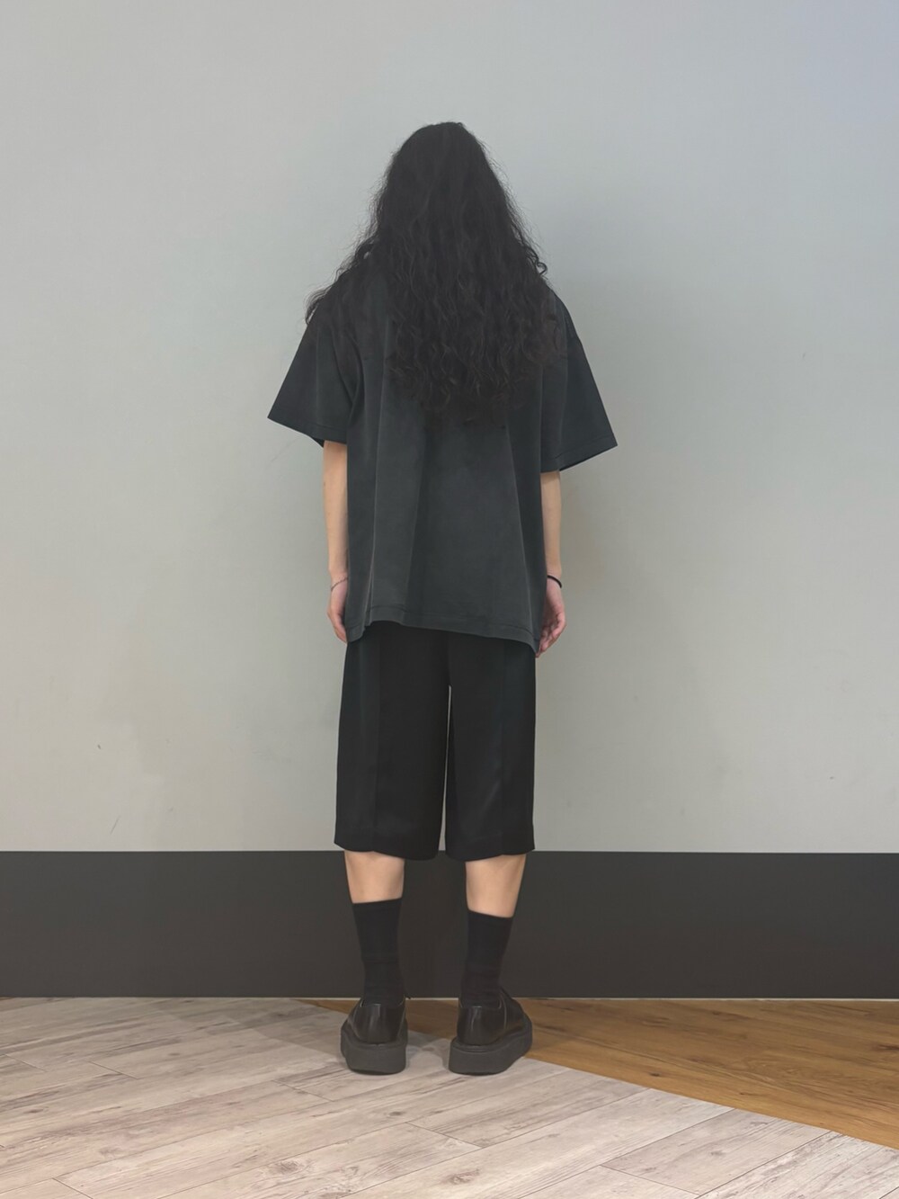 ブラック系のTシャツ/カットソーを着用したメンズの春コーディネートの2枚目の写真