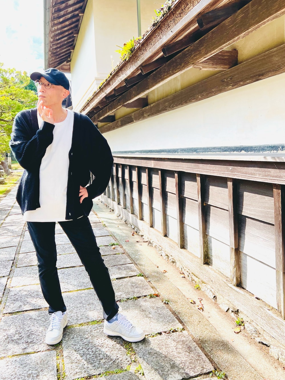 ブラック系のカーディガン/ボレロ、ホワイト系のTシャツ/カットソー、ブラック系のデニムパンツを着用したメンズの秋コーディネートの2枚目の写真