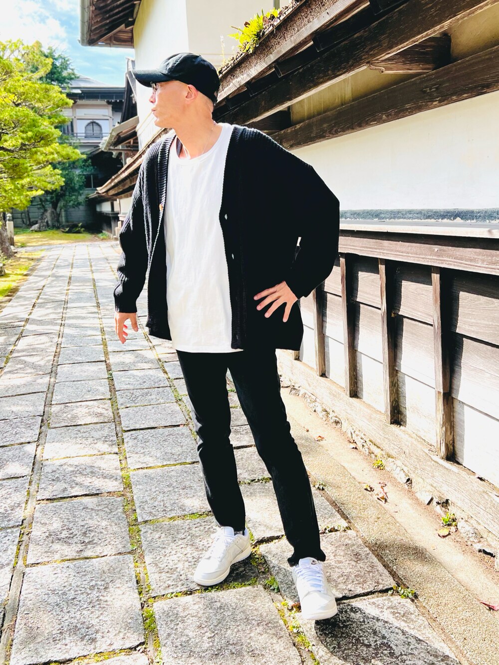 ブラック系のカーディガン/ボレロ、ホワイト系のTシャツ/カットソー、ブラック系のデニムパンツを着用したメンズの秋コーディネートの3枚目の写真