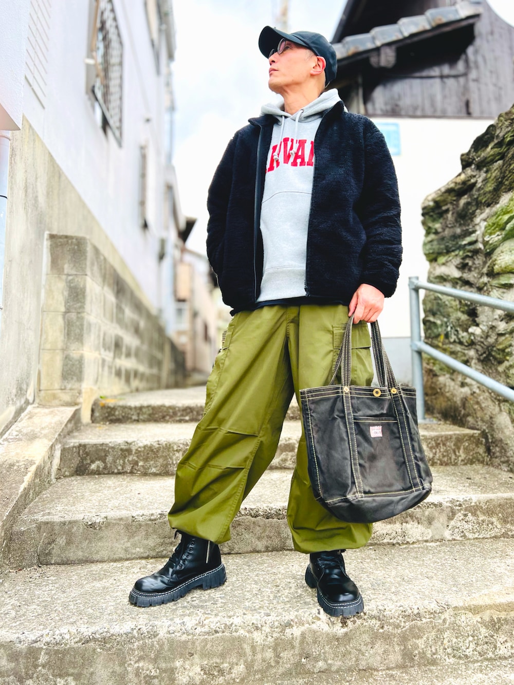 ブラック系のジャケット/アウター、グリーン系のカーゴパンツ、ブラック系のブーツを着用したメンズの冬コーディネートの2枚目の写真