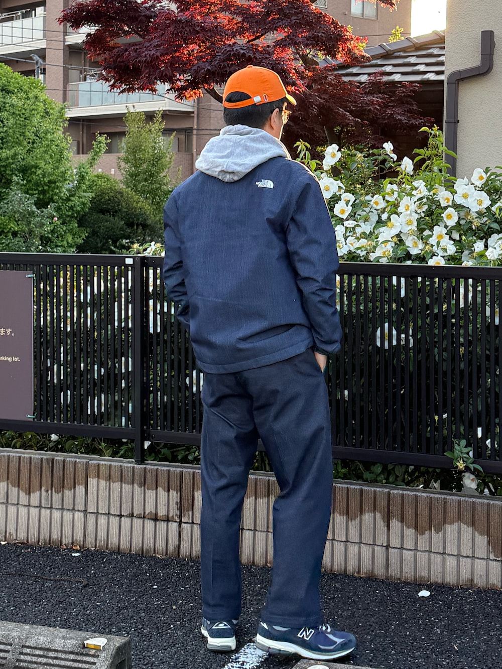 グレー系のパーカー、ブルー系のナイロンジャケット、ブルー系のチノパンツを着用したメンズの春コーディネートの3枚目の写真