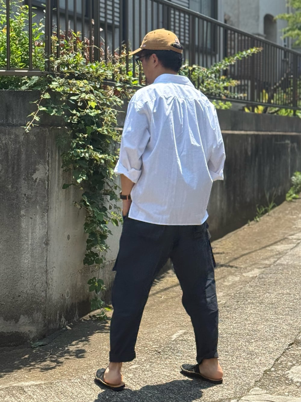 ブラック系のカーゴパンツ、ブラック系のサンダル、ブラック系のTシャツ/カットソーを着用したメンズの夏コーディネートの2枚目の写真