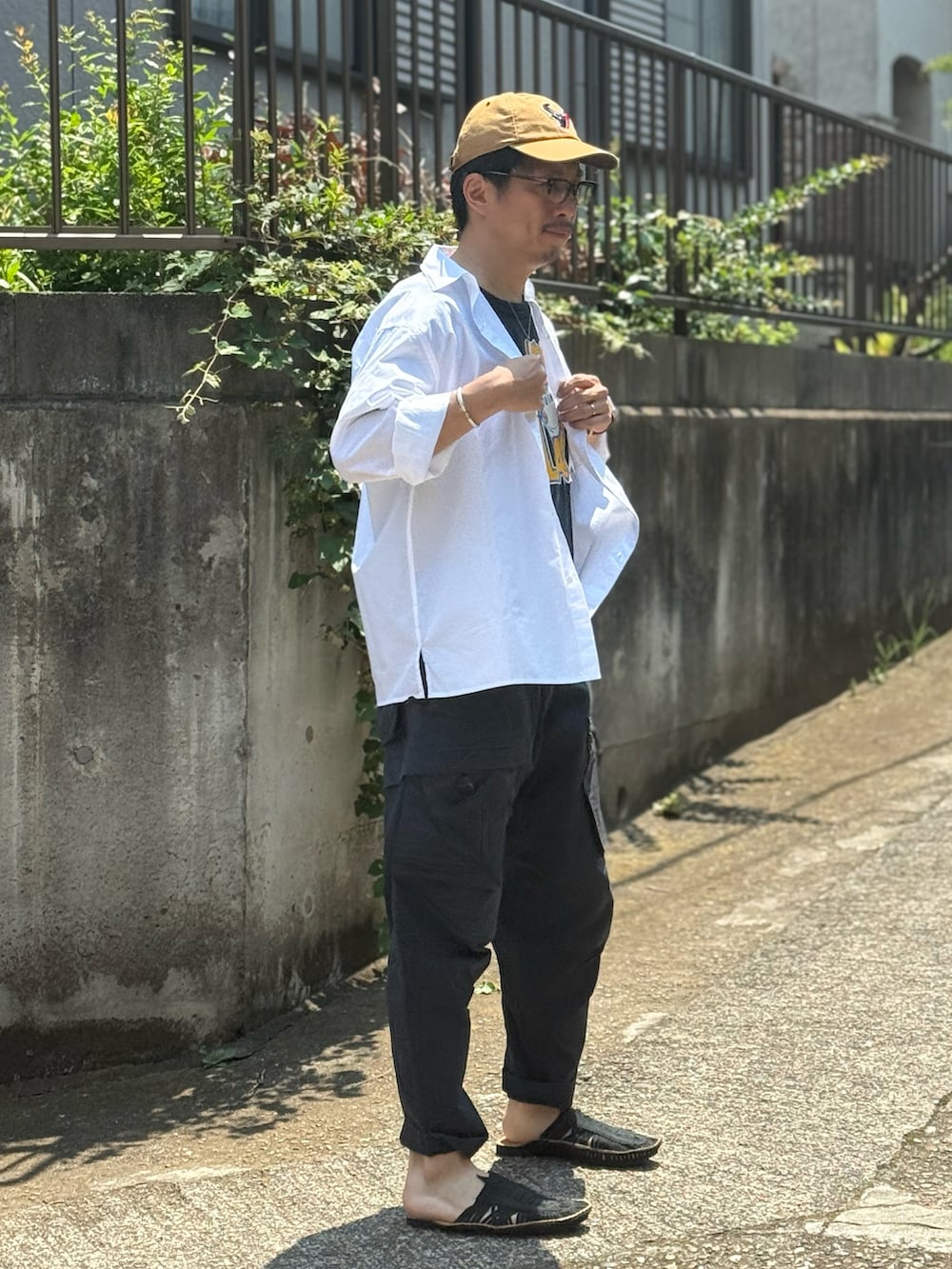 ブラック系のカーゴパンツ、ブラック系のサンダル、ブラック系のTシャツ/カットソーを着用したメンズの夏コーディネートの3枚目の写真