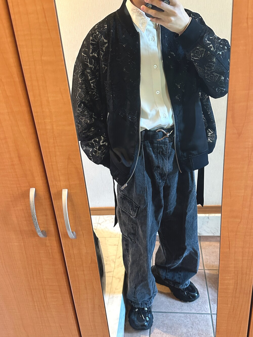 ブラック系のテーラードジャケット、グレー系のデニムパンツ、ブラック系のスニーカーを着用したメンズの春コーディネートの2枚目の写真