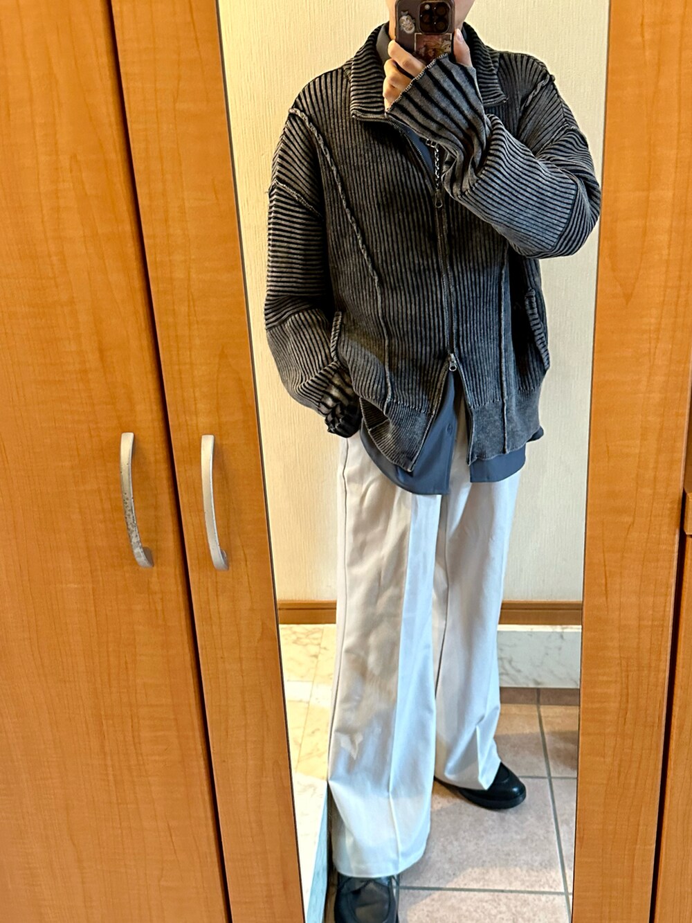 ブラック系のニット/セーター、ブラック系のシューズ、グレー系のスラックスを着用したメンズの秋コーディネートの2枚目の写真