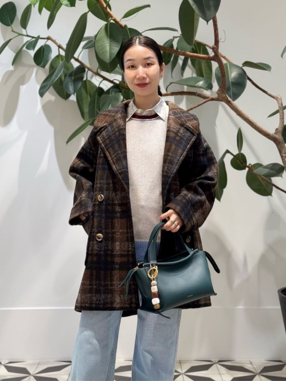 ブルー系のデニムパンツ、ホワイト系のシャツ/ブラウス、ホワイト系のキャミソールを着用したレディースの冬コーディネートの2枚目の写真