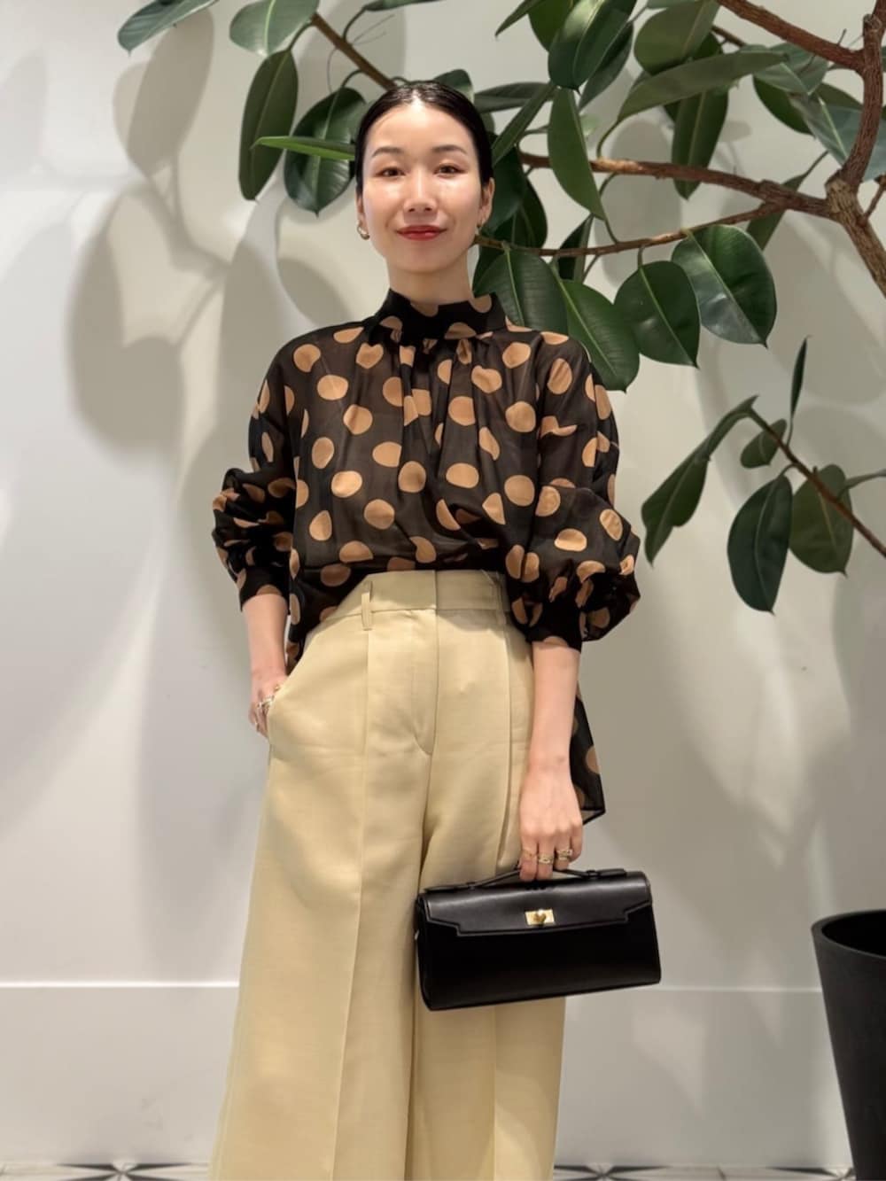 イエロー系のスラックス、ホワイト系のキャミソール、ブラック系のシャツ/ブラウスを着用したレディースの夏コーディネートの2枚目の写真