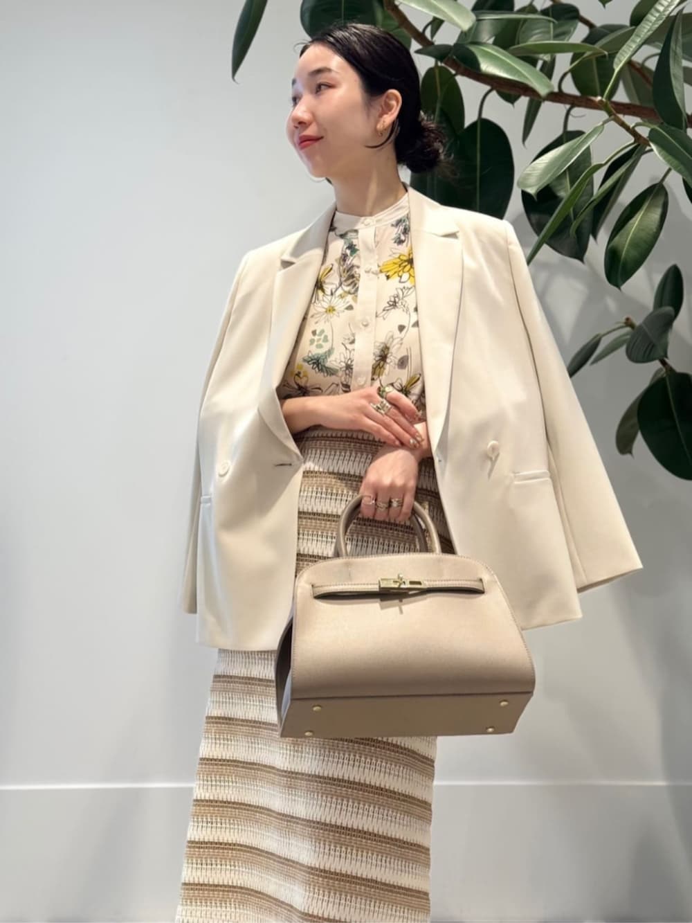 ホワイト系のキャミソール、ベージュ系のテーラードジャケット、イエロー系のシャツ/ブラウスを着用したレディースの春コーディネートの2枚目の写真