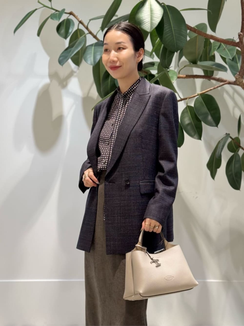 ブラック系のキャミソール、ブルー系のピーコート、ブラウン系のテーラードジャケットを着用したレディースの冬コーディネートの3枚目の写真