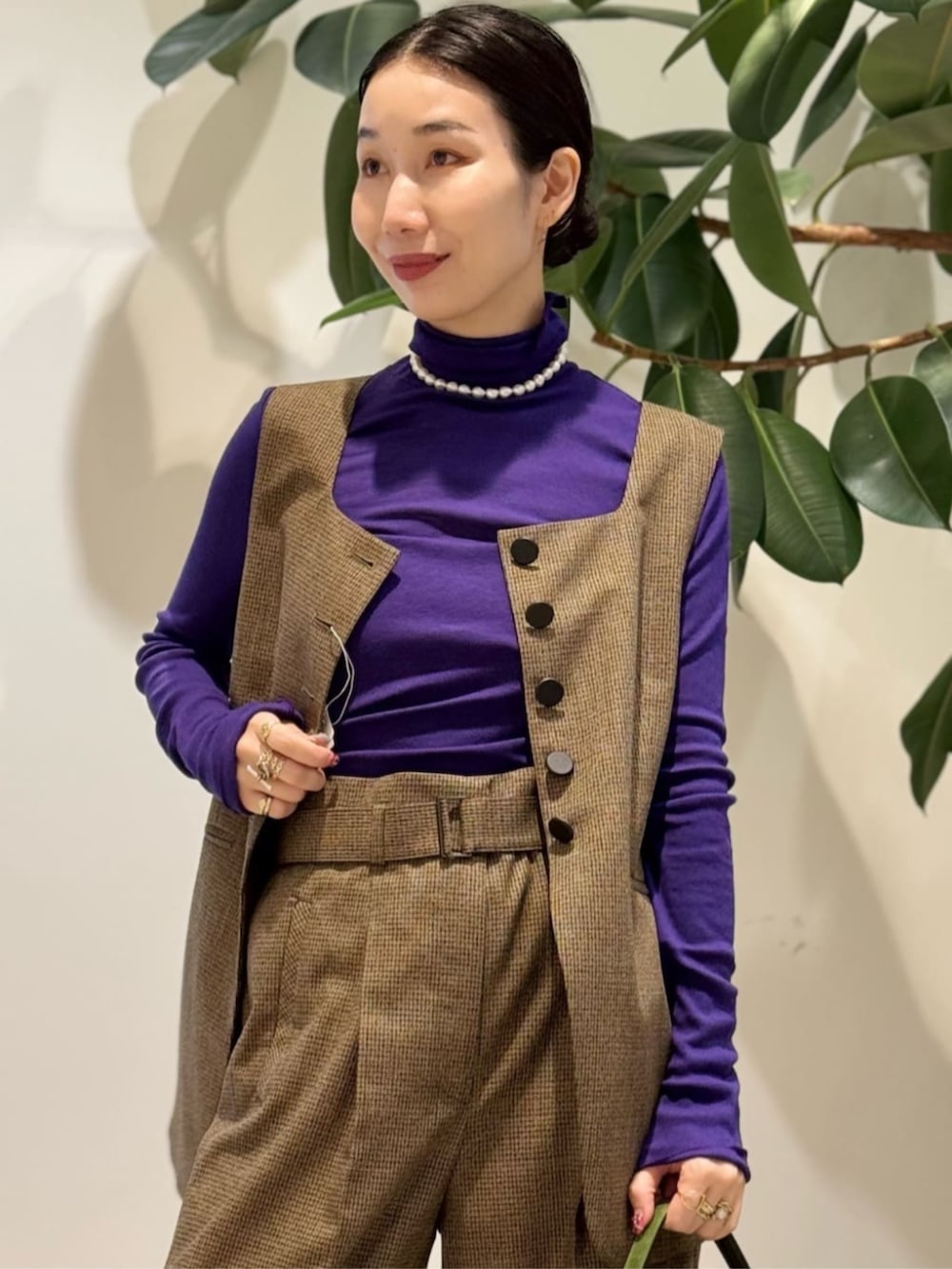 パープル系のTシャツ/カットソー、ブラウン系のその他パンツ、ブラウン系のベストを着用したレディースの秋コーディネートの3枚目の写真