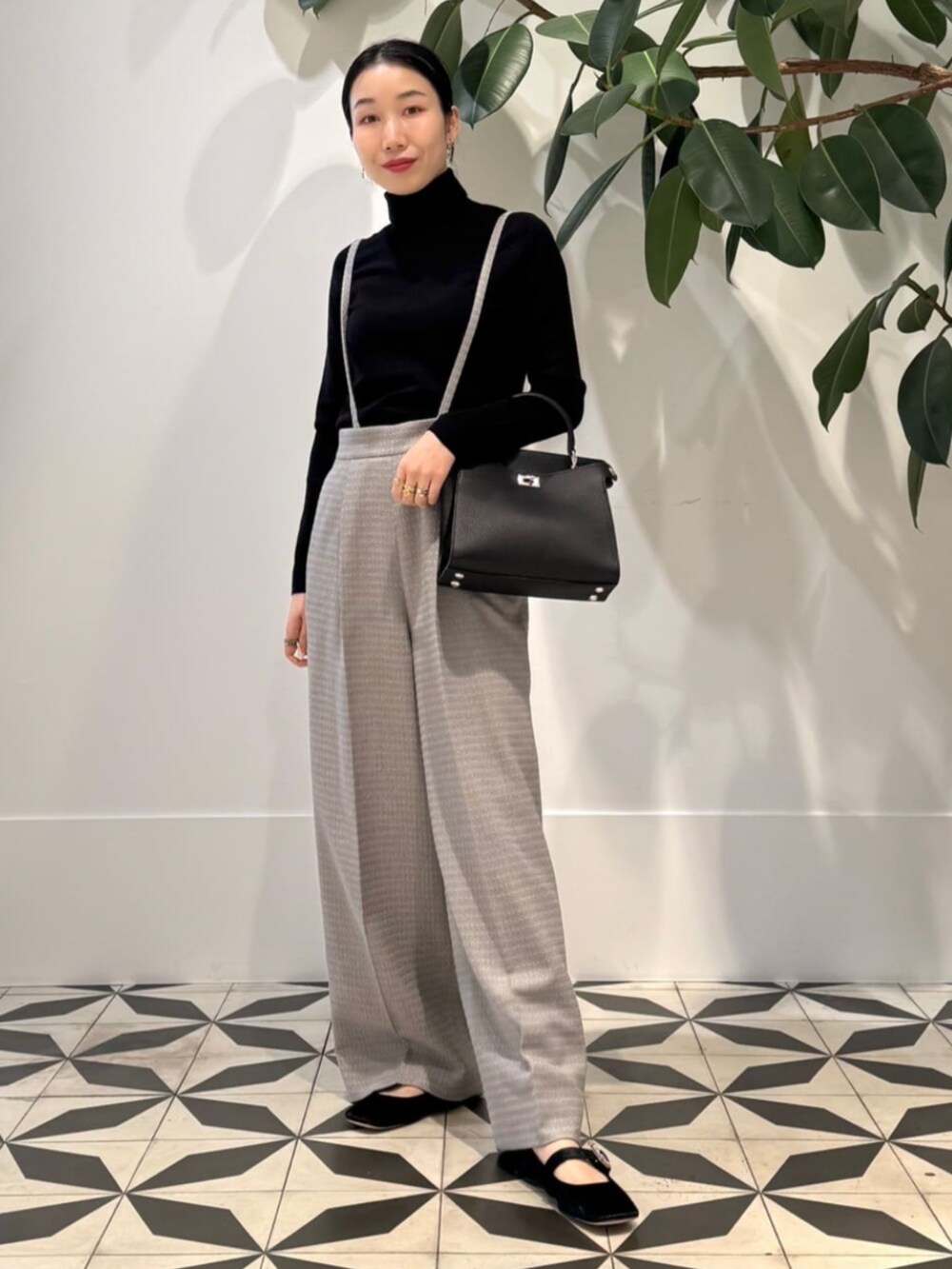 グレー系のベスト、ブラック系のニット/セーター、グレー系のその他パンツを着用したレディースの冬コーディネートの2枚目の写真