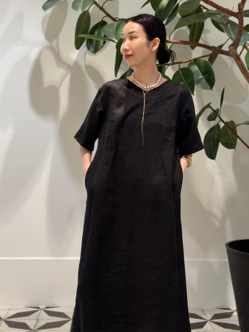 ブラック系のキャミソール、ベージュ系のトートバッグ、ブラック系のワンピースを着用したレディースの夏コーディネートの3枚目の写真