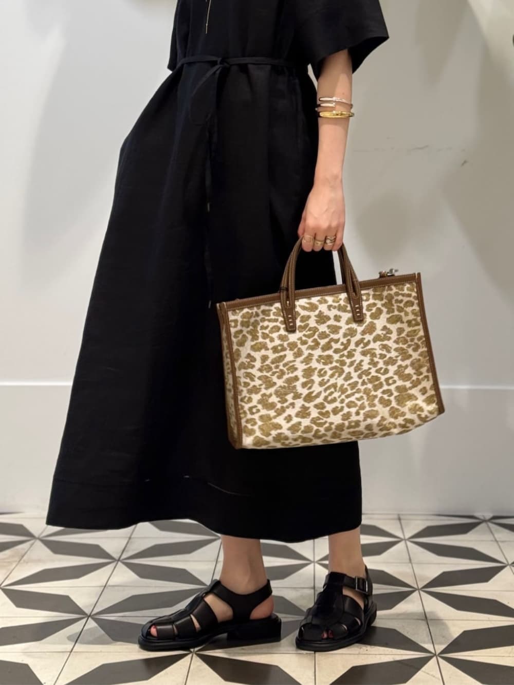 ブラック系のキャミソール、ベージュ系のトートバッグ、ブラック系のワンピースを着用したレディースの夏コーディネートの4枚目の写真