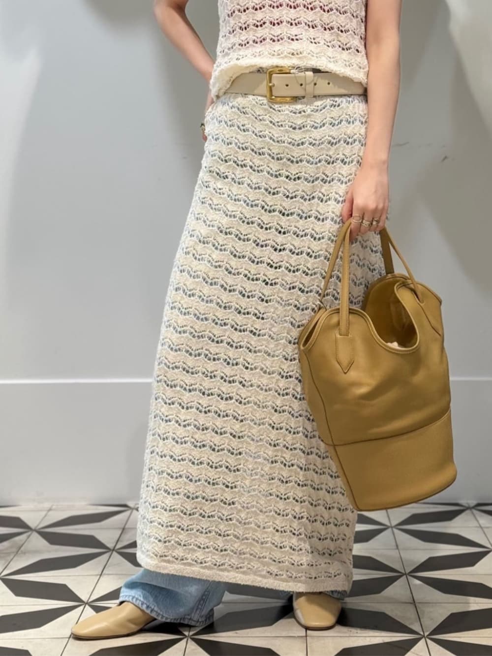 ブルー系のデニムパンツ、ベージュ系のパンプス、レッド系のタンクトップを着用したレディースの夏コーディネートの3枚目の写真